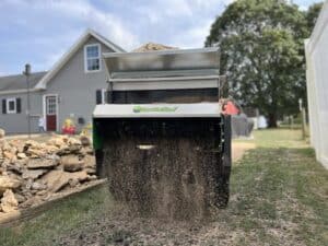 100 sp topdresser spreading sand on a yard for lawn leveling