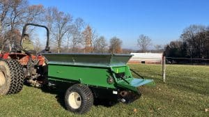 320 sand and compost spreader pulled by a case tractor